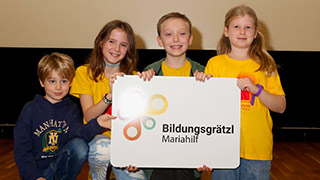 Kinder mit Schild "Bildungsgrtzl Mariahilf"