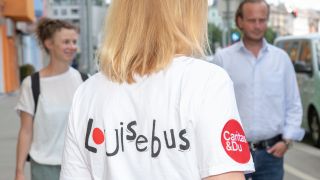 Junge Frau trgt T-Shirt mit Aufschrift "Louisebus"