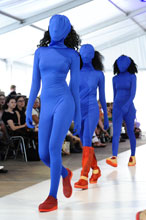 Modeschülerinnen in blauem engen Anzug, der auch das Gesicht bedeckt