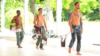 Männliche Models auf dem Laufsteg präsentieren Taschen