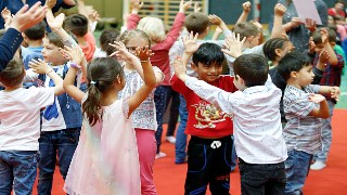 Kinder tanzen mit Hnden in der Hhe