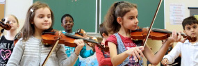 Mädchen spielen Geige in einer Volksschulklasse