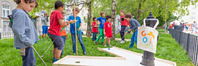 Kinder nutzen den öffentlichen Grünraum zum Minigolf spielen