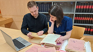 Women sitting at a desk and talking to a man
