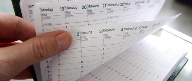 Hand turning the pages of a calender