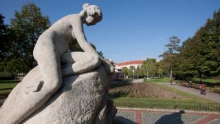 A fountain with a stone statue of a woman