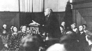 historic photo: audience listening to a man speaking