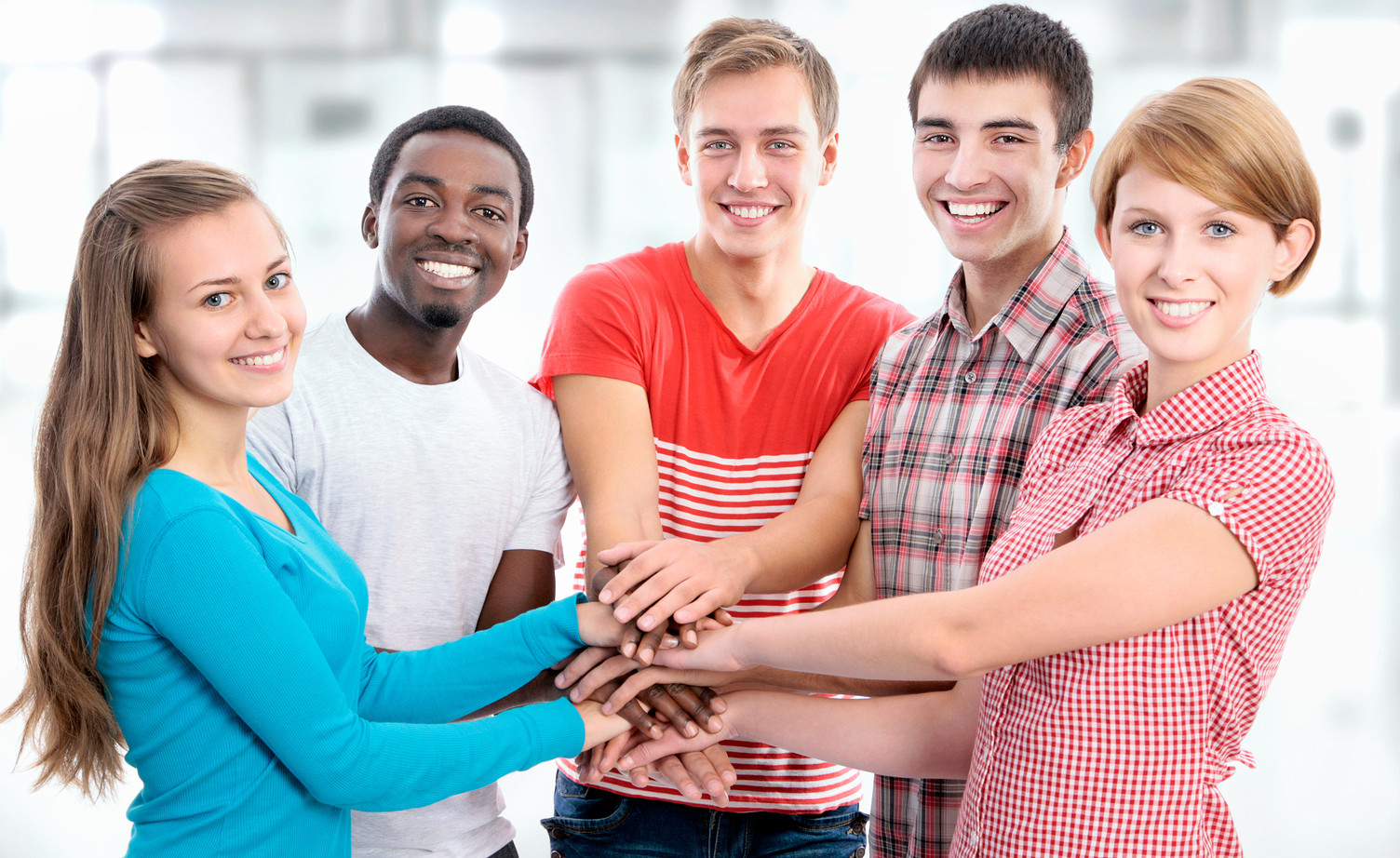 group of young people stacking their hands