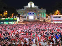 Fans in the Fan Zone in front of the Burgtheater at night