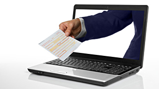 Eine Hand reicht einen Zahlschein aus einem Laptop-Bildschirm.