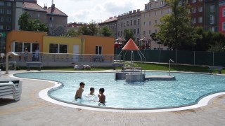 Kinderbecken im Freien und drei badende Kinder