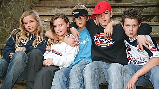 Eine Gruppe Jugendlicher sitzen auf einer Bank