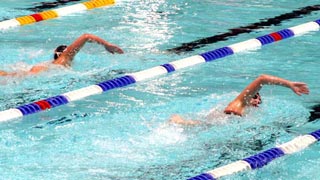 Zwei Schwimmer ziehen ihre Bahnen im Schwimmbecken
