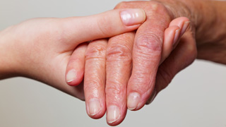 Eine jüngere Hand hält eine ältere Hand