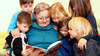 Lesende Frau umringt von Kindern