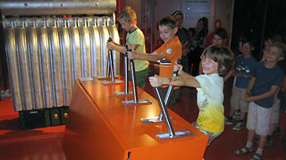 Kinder an einer Maschine, die Energie erzeugt