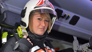Eine Feuerwehrfrau sitzt in einem Feuerwehrauto