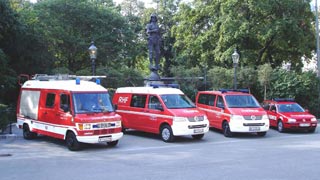 Drei rote Feuerwehrkleinbusse, ein Feuerwehrauto