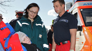 Akutbetreuerin und Rettungsmann im Gespräch mit einem Verletzten