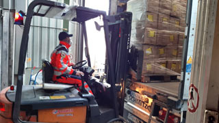 Gabelstapler verlädt Hilfsgüter in einen Lastwagen
