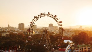 Das Riesenrad im Sonnenuntergang, dahinter Gebäude