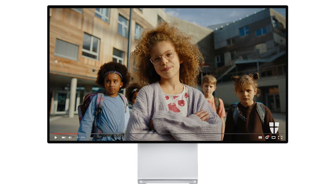 Standbild eines Videos: Vier Kinder stehen vor einem modernen Schulgebäude, eines von ihnen blickt selbstbewusst in die Kamera. copyright: mxr