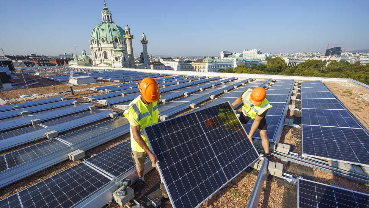 Kapitelbild: Zwei Arbeiter montieren ein PV-Modul am Dach des Wien Museum. Copyright: Wien Energie/Christian Hofer