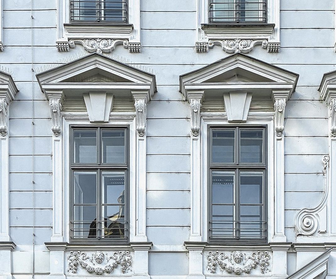 Dekorierte Gründerzeitfassade mit sanierten historischen Kastenfenstern.