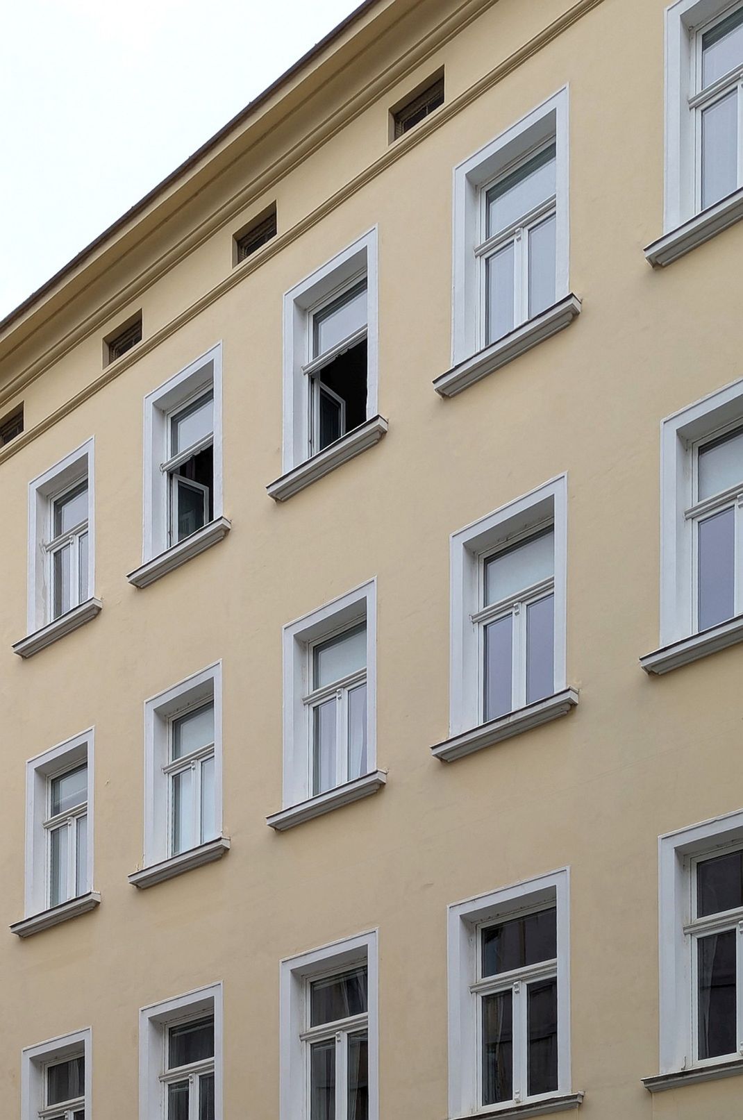Entdekorierte Gründerzeitfassade. Fenstertausch auf einschichtige Rahmenstockfenster mit schlankem Rahmen, historisch profiliertem Kämpfer bzw. Stulp und charakteristischer T-Teilung, um das historische Erscheinungsbild nachzuempfinden.