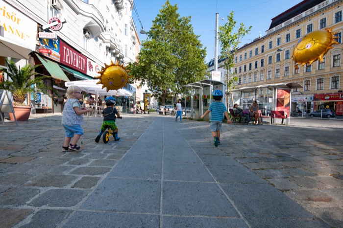 Kinder spielen in einer breiten Fußgängerzone