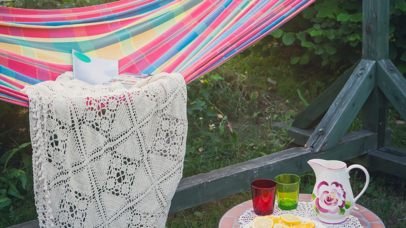 A hammock with a blanket and a magazine outside in a garden.
Copyright: Aleksandr_Kendenkov