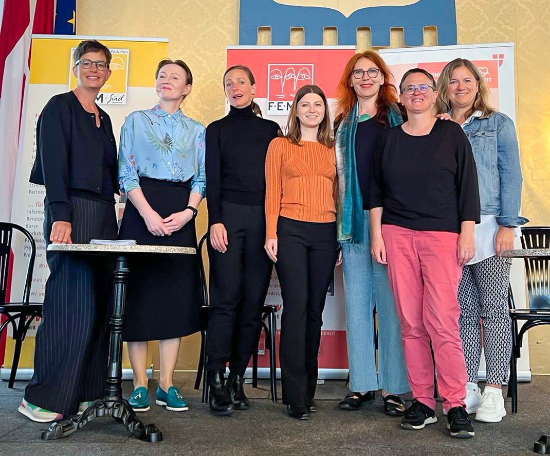 Das Koordinationsteam posiert auf einer Bühne im Wiener Rathaus. Es sind sieben Personen, sie lächeln.