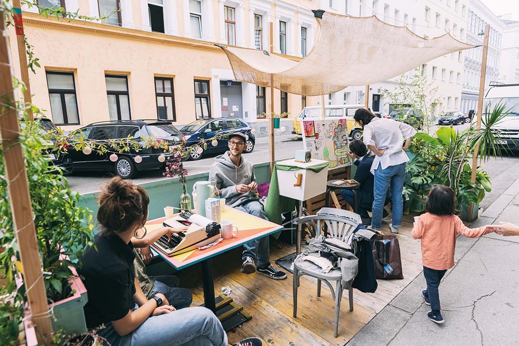 Foto von einer Grätzl Oase mit Personen die sich unterhalten, malen und spielen.