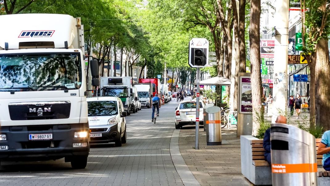 Ein LKW fährt auf der Mariahilferstraße auf den Betrachter zu. Im Gegenverkehr ist eine Person mit dem Rad unterwegs.