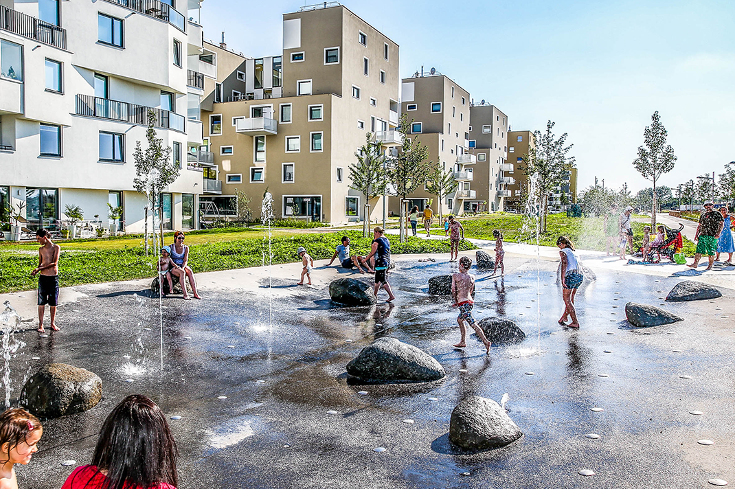 Wasserspielplatz in einem neuem Stadtteil mit spielenden Kindern und Jugendlichen