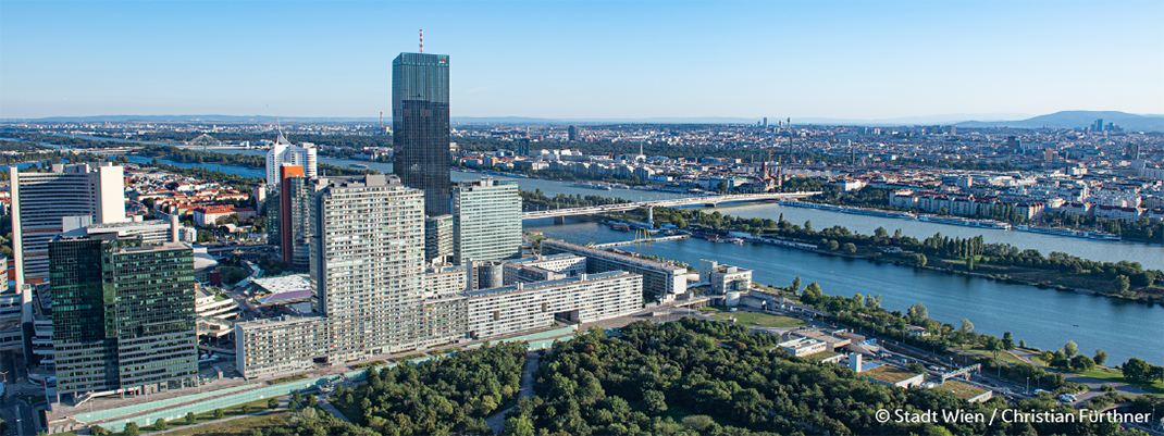 Blick von oben auf die Hochhäuser der Donauplatte und auf die Donau