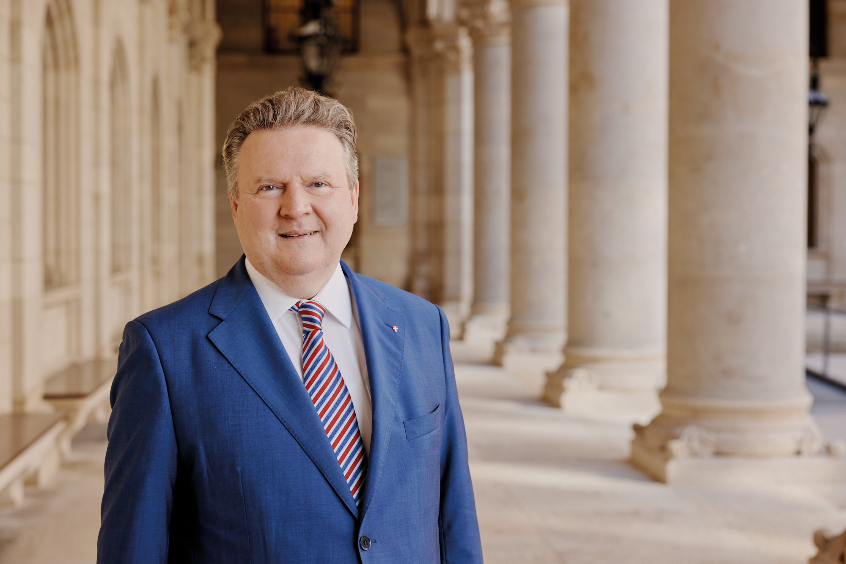 Portrait von Bürgermeister Dr. Michael Ludwig: Mann im Anzug vor Säulen des Wiener Rathauses