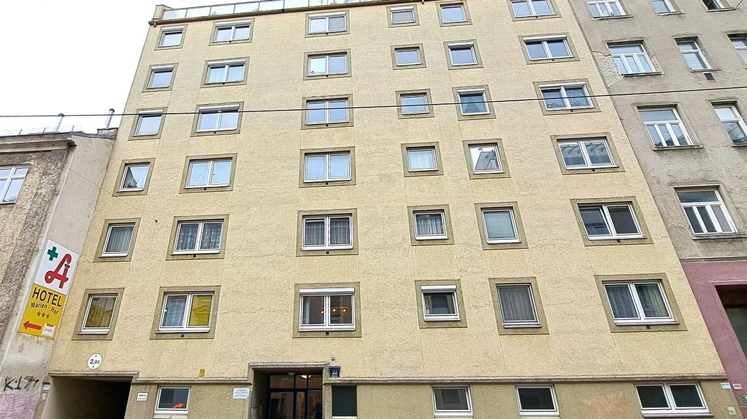 Exterior view of the building at Hartlgasse 22. A six-storey residential block dating from the 1980s, with square windows and a square façade. The façade is beige.