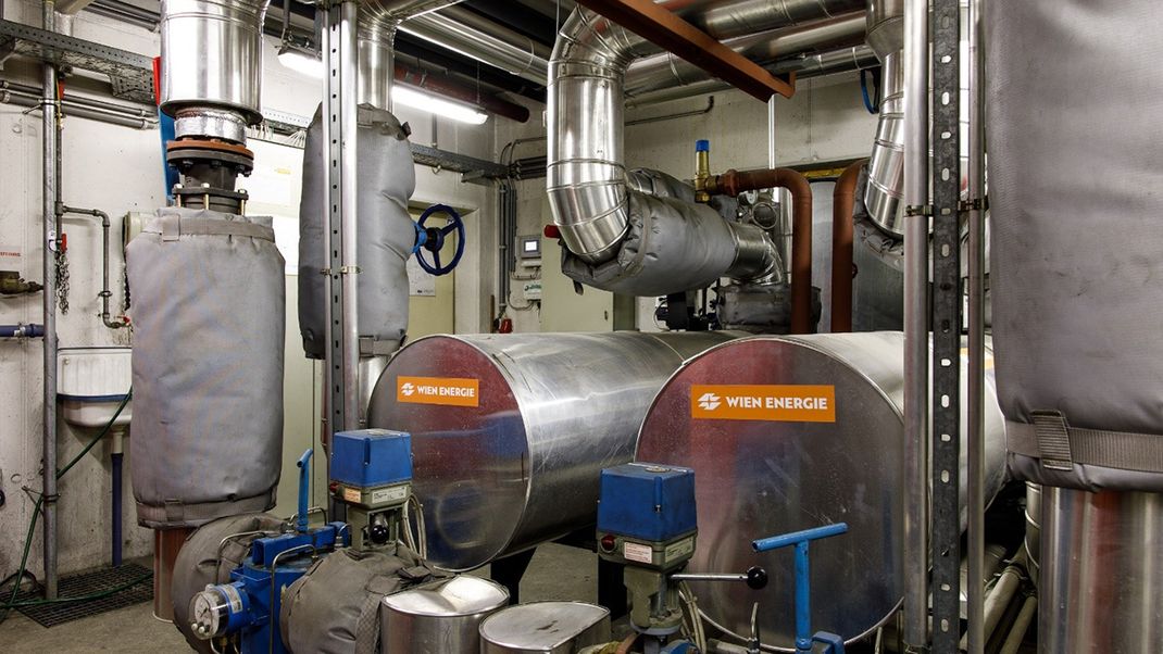 A technical installation featuring pipes and barrels, all silver-coloured with a touch of blue.