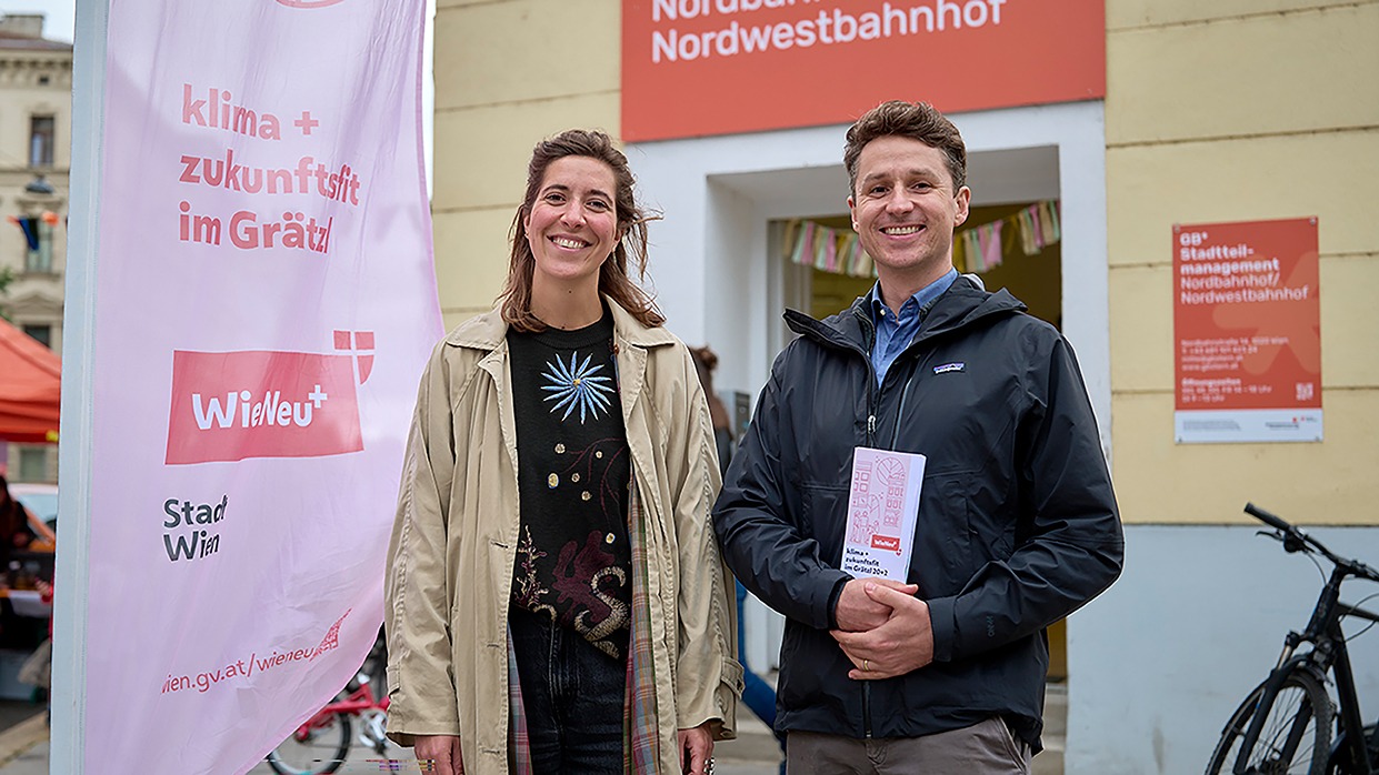 Kapitelbild: Eine lächelnde Mitarbeiterin und ein lächelnder Mitarbeiter von WieNeu+ stehen vor dem Lokal der Gebietsbetreuung Stadterneuerung - Nordbahnhof/Nordwestbahnhof im Alliiertenviertel. Neben der Mitarbeiterin steht eine WieNeu+ Beachflag, der Mitarbeiter hält einen WieNeu+ Folder in der Hand.
Copyright: Stadt Wien / Markus Wache