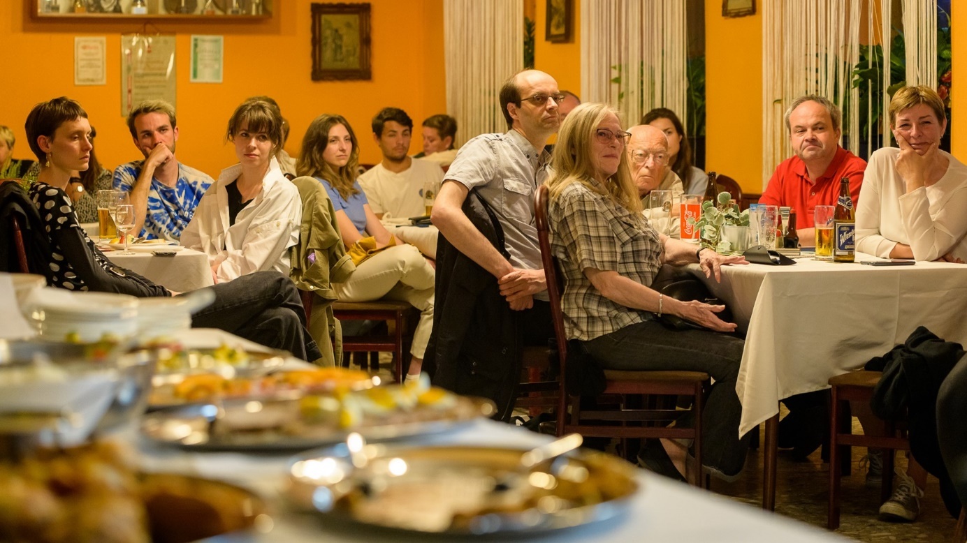 Zuhörer*innen einer Lesung im Wirtshaus mit vorne unscharf dem Buffettisch. Copyright: Haselbauer