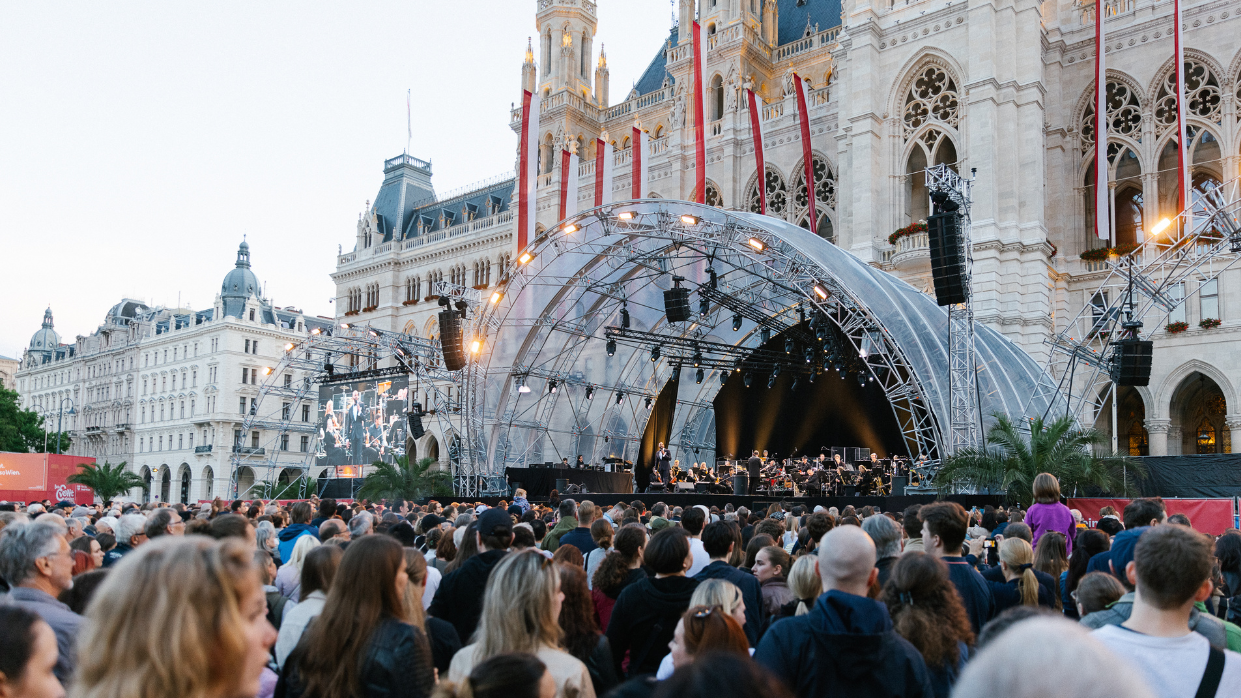 Kapitelbild: Bühne des Wienliebe Festivals vor dem Wiener Rathaus, mit einer großen Menschenmenge im Vordergrund.