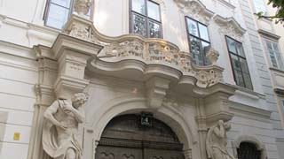 Ausschnitt einer Hausfassade, Geschwungener steinerner Balkon ber dem barocken Eingangsportal, Sicht von unten