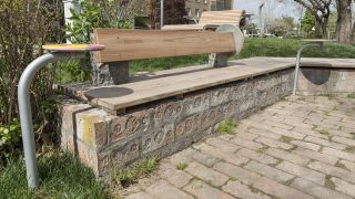 Holzbank auf gemauertem Stein im Park