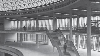 Schwarz-Weiß-Foto, runder Innenraum mit Freitreppe, die in Galerie mündet