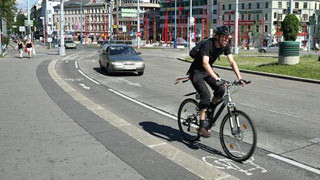 Radfahrer mit Helm unterwegs auf dem Radweg am Grtel
