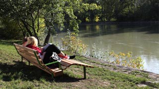Junges Pärchen auf einer Sitzbank an den Ufern des Donaukanals