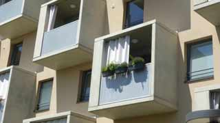 Detailausschnitt Fassade in Schrägansicht; quadratische, regelmäßig versetzte Balkone aus Sichtbeton