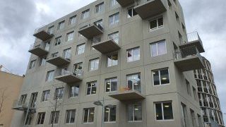 Ansicht auf Gebäude aus Sichtbeton und unregelmäßig versetzten Balkonen mit Betonböden und Metallgeländer
