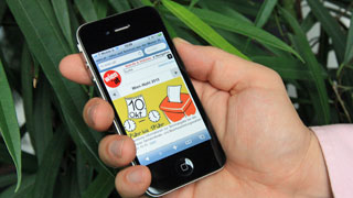 Ein Benutzer hlt ein iPhone mit geffneter wien.at-Seite zur Wahl in der Hand